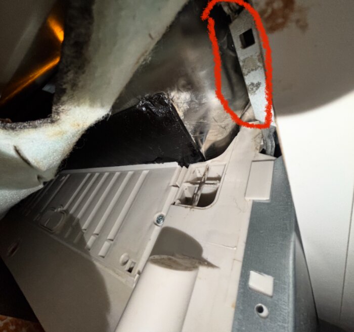 Under diskmaskinen med isolering undanröjd syns ett läckageområde markerat i rött, där vatten rinner ut.