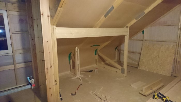 Takstol i barnrum med modifierade snedsträvor, stödben kvar. Visar läkt för planerad sängyta, verktyg och träbitar spridda på golvet.