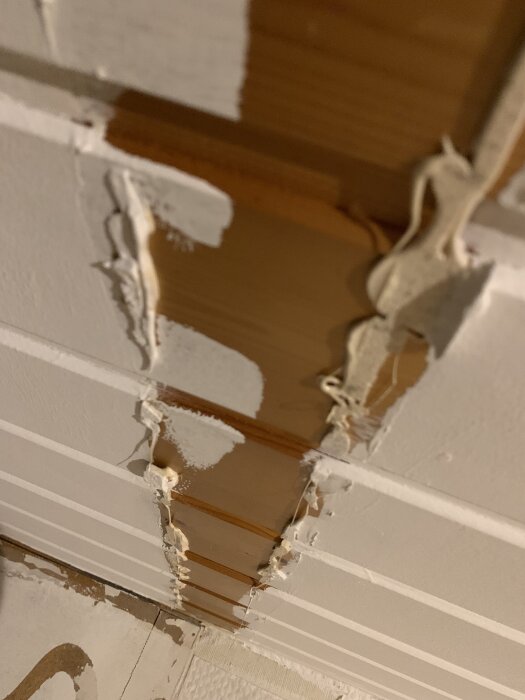 Limrester kvar på ett tak efter att fejk-bjälkar av frigolitliknande material tagits bort.