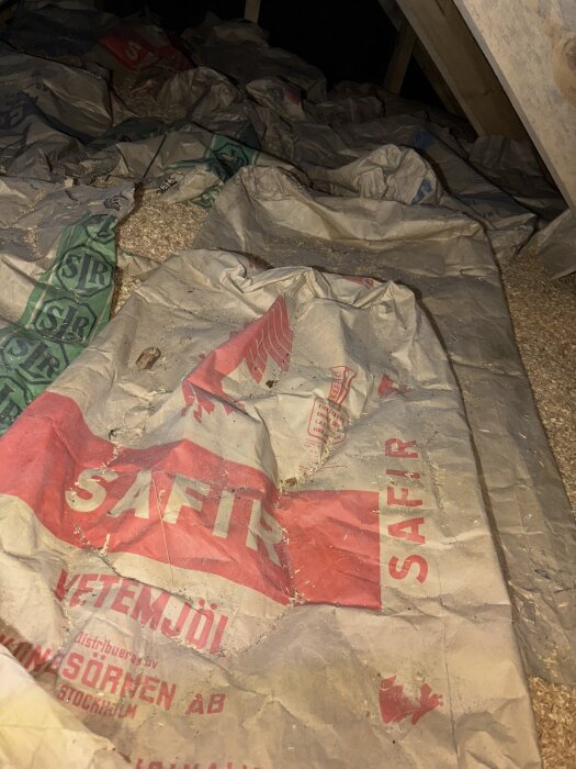 Mjölsäckar från "Safir" i en vind med spån, ovanför svart råspont.