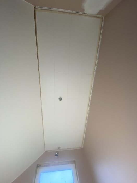 Takhörn med olika vinklar, ena sidan 45° och den andra 90°, vid ett fönster. Väggen målad i beige.