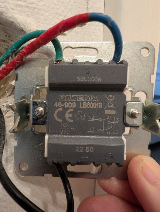 Väggmonterad elektrisk brytare från Biltema med synliga röda, gröna, blå och svarta kablar, märkt SBL 100W och modellerad 46-909 LB80019.