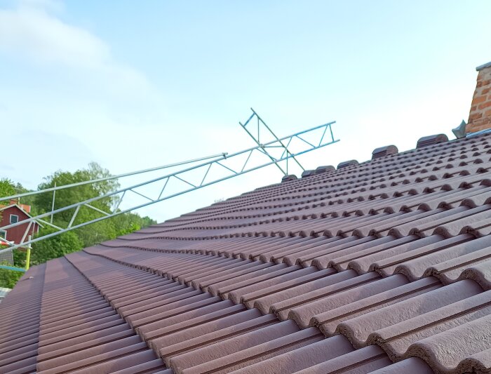 Tak med bruna takpannor och en ställning ovanpå, vilket illustrerar behovet av korrekt uppriktning vid byggprojekt för att undvika problem.