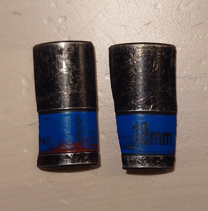 Två slitna 18 mm hylsor med blå markering, används för att ta bort sommardäck.