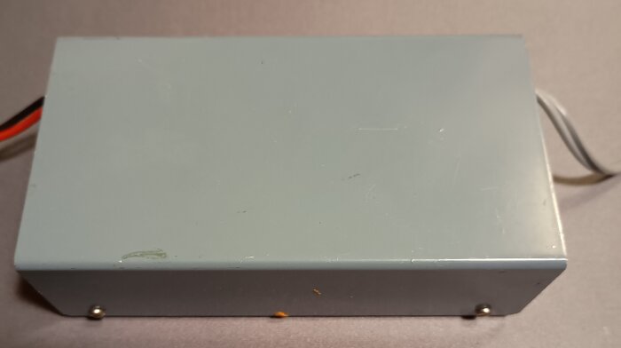 Hemmagjord sändare i grått metallhölje, med kablar synliga på sidorna, troligen för kanal 27.