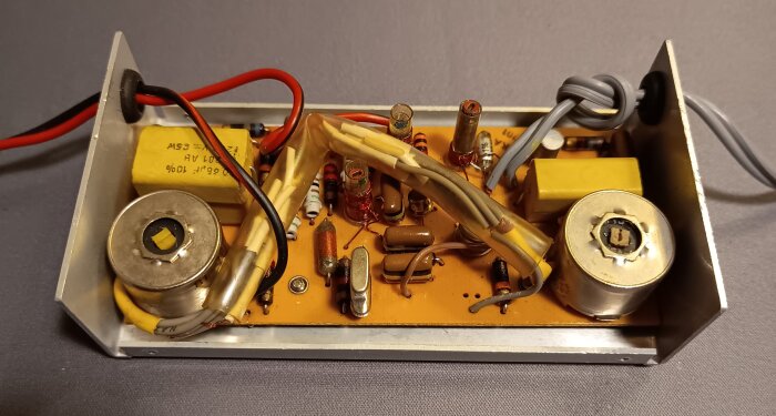 Hemmabygge av en sändare med kristall för kanal 27, innehållande olika elektroniska komponenter och kablar i en metallram.