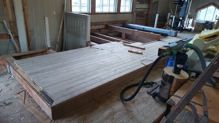 Rivning av gradäng på körläktare, med gamla pelare synliga. Verktyg och byggmaterial finns i bakgrunden.