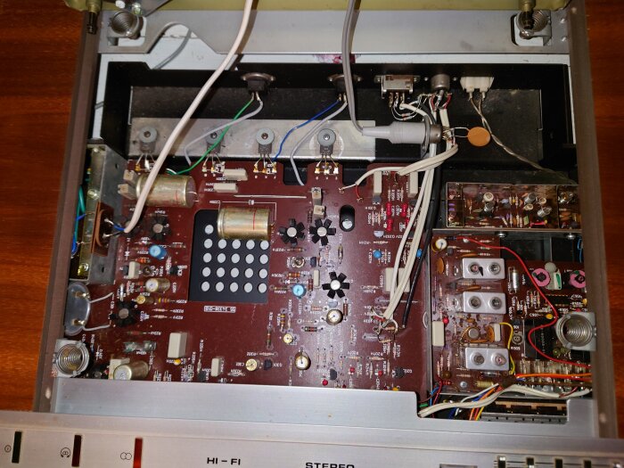 Inuti en Skantic Harmoni 17S vinylspelares elektroniska komponenter, med kretskort och sladdar synliga.