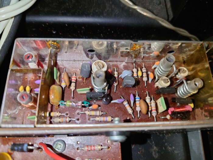 Närbild av insidan av en vinylspelares elektronik med motstånd, kondensatorer och andra komponenter på ett kretskort.