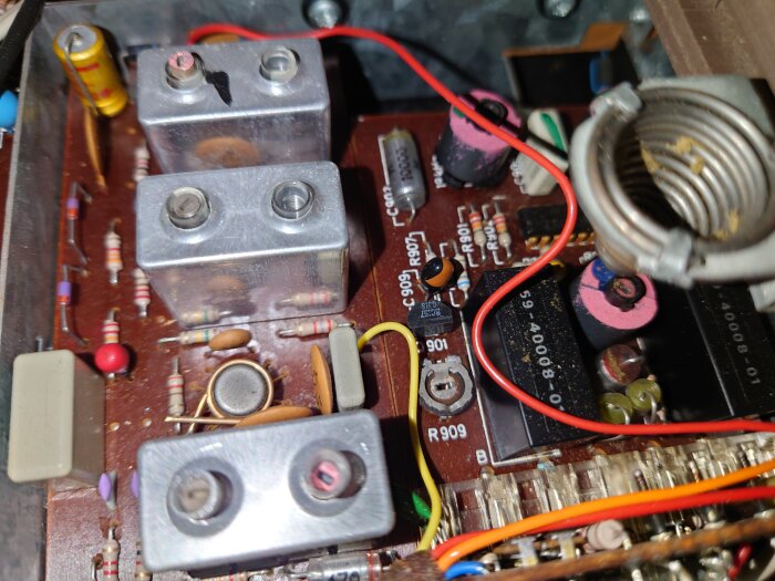 Närbild av insidan av en vinylspelares elektronik, med kretskort, motstånd och kablar, varav några kablar är röda och gula.