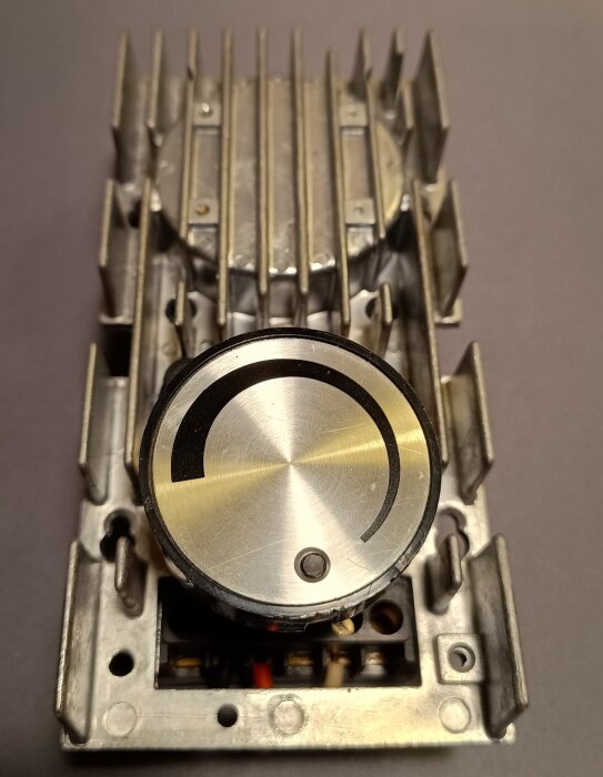 Äldre dimmer med stor vridknapp och kylflänsar i pressgjuten aluminium för upp till 1200 W glödljus, visar robust konstruktion.