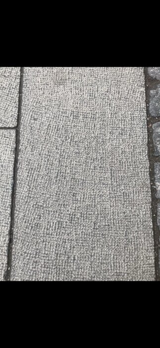 Marksten med kvadratisk textur vid kaj i Saltsjöqvarn, Nacka.