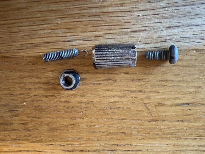 Demonterade skruvar och komponenter på en träyta, inklusive en slipad skruv och en torx skruv, diskuterade i ett forum om byggprojekt.