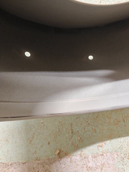 Närbild på två hål i en spånsug där handtaget skulle sitta, vilket orsakade läckage.