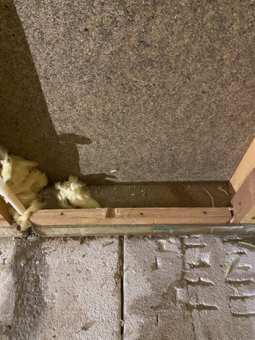 Fuktig isolering och träkonstruktion vid golv i byggnadsprojekt.