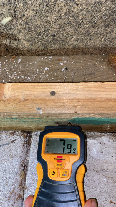 Fuktmätare visar 7,9% fuktighet vid golvnivå på en träyta.