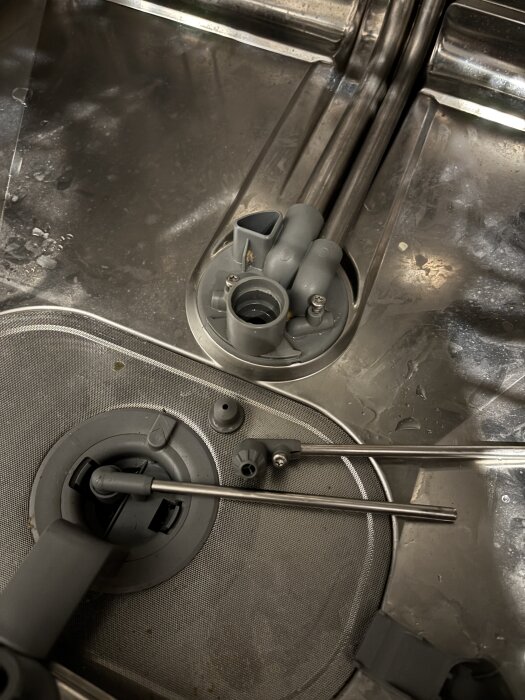 Diskmaskinens inre med avlägsnade delar, inklusive ett skyddsnät och spolväxlare i fokus.