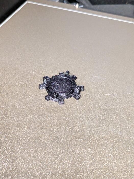 3D-utskriven piston dampener för dyckertpistol, svart TPU-material, återskapad efter original, ligger på en beige yta.