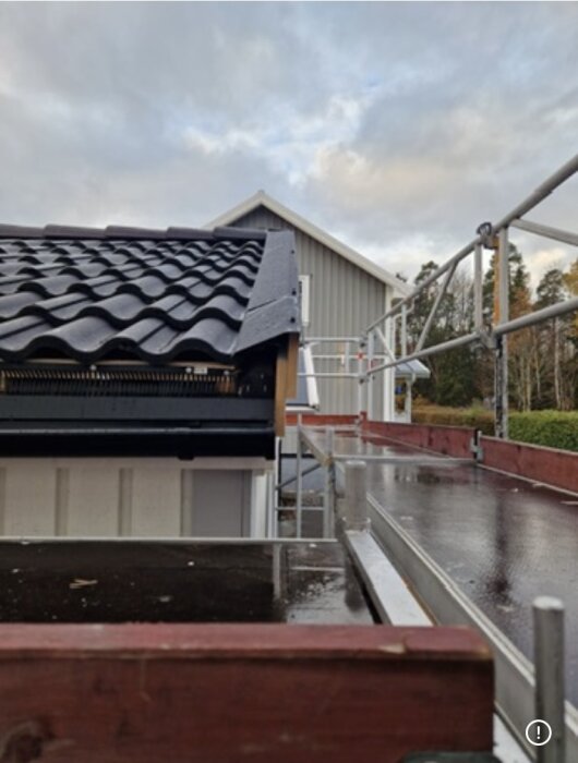 Närbild på ett nylagt garagetak med svart takpapp och läkt, där fågelskyddet är felvänt och en öppning syns under takkanten.