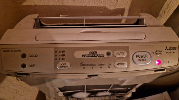 Avfuktare med isbildning vid filtret, indikeringslampor lyser. Problem med vattenläckage och två isklumpar synliga.