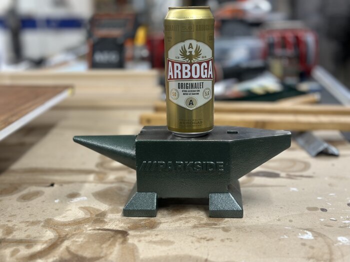 Gjutjärnsstäd av märket Parkside placerat på en arbetsbänk, med en Arbogaburk stående ovanpå. Bakgrunden visar verktyg och material.