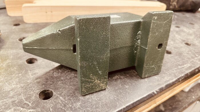 En massiv grön städ på ett arbetsbord, tyngre än en annan modell enligt användarens beskrivning.