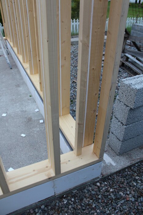 Träramar och isolering av frigolit i garagebygge med reglar, visar konstruktionen för att minimera kontakt med utsidan.