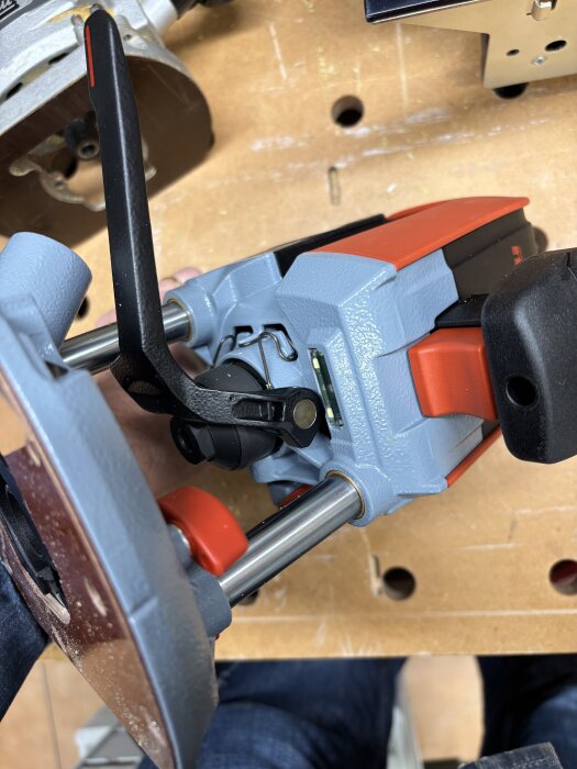 Närbild av en mellanfräs på en arbetsbänk, med synlig handtagsdel och delar av fräsens mekanism i fokuserad vinkel.