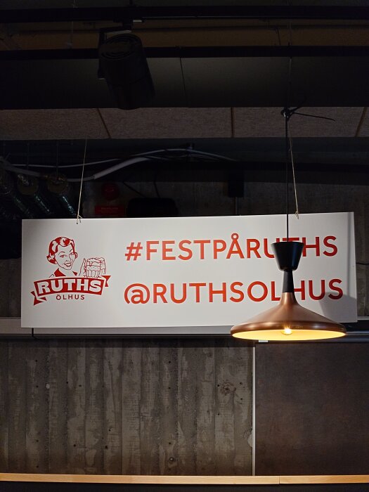 Skylt på Ruths Ölhus med texten "#FESTPÅRUTHS @RUTHSÖLHUS" och en bild av en person som håller en öl.