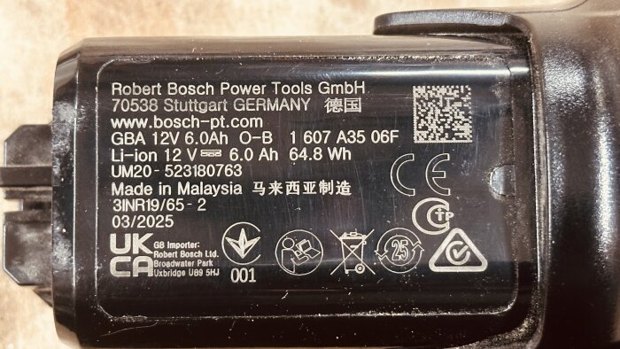 Etikett på ett Bosch 12V 6.0Ah litiumjonbatteri, tillverkat i Malaysia, med diverse märkningar och tillverkarens information.
