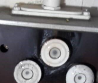 Gammaldags elcentral med tre porslinssäkringar monterad på en vägg.