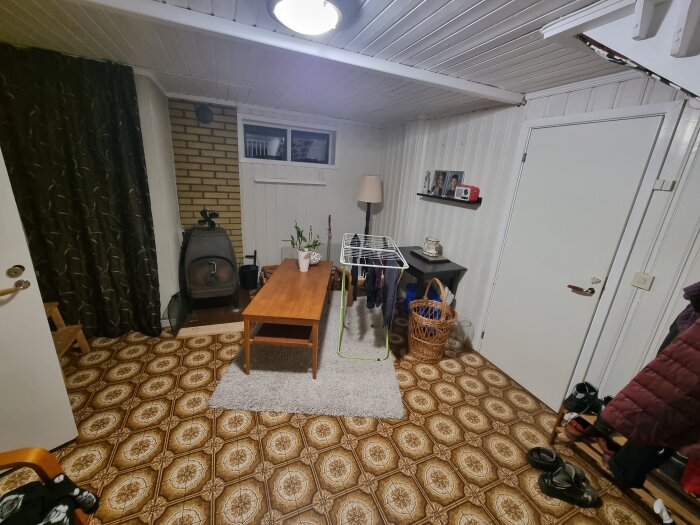 Gillestuga med bord, vedspis, klädhängare och plantor; diskussion om bastubygge.