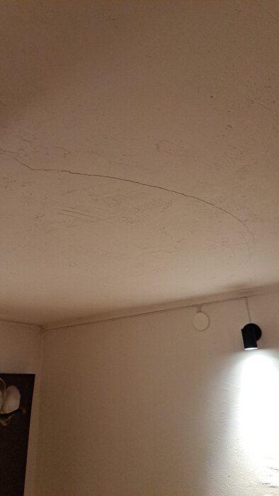 Sprickor i ett källartak av betong, uppkomna nyligen, med en lampa monterad på väggen. Tråden diskuterar eventuell åtgärd.