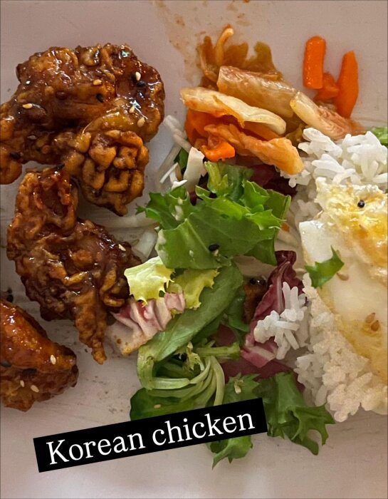 Tallrik med koreansk kyckling, sallad, ris och kimchi.