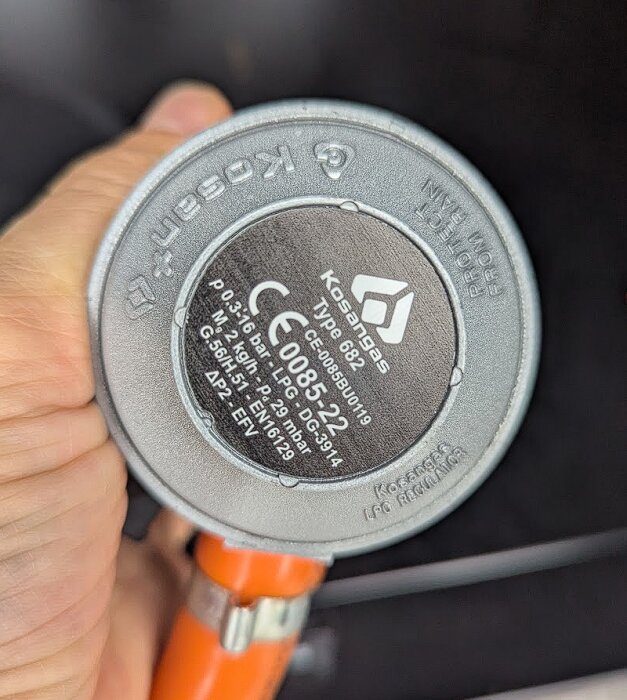 Gasolregulator av märket Kosangas med en orange slang.