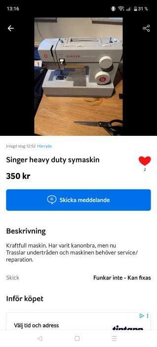 Symaskin av märket Singer Heavy Duty står på ett träbord bredvid en sax.
