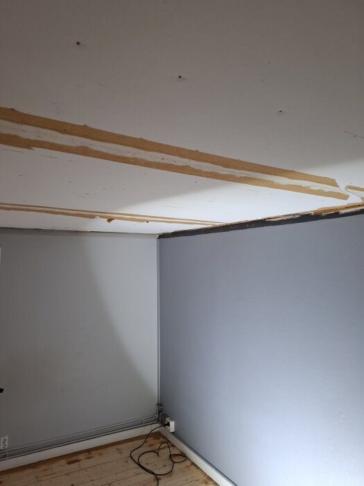 Tak med avlägsnade skarvlister och många skruvhål, vitt med bruna streck, del av renoveringsprojekt för att återställa det slätt.