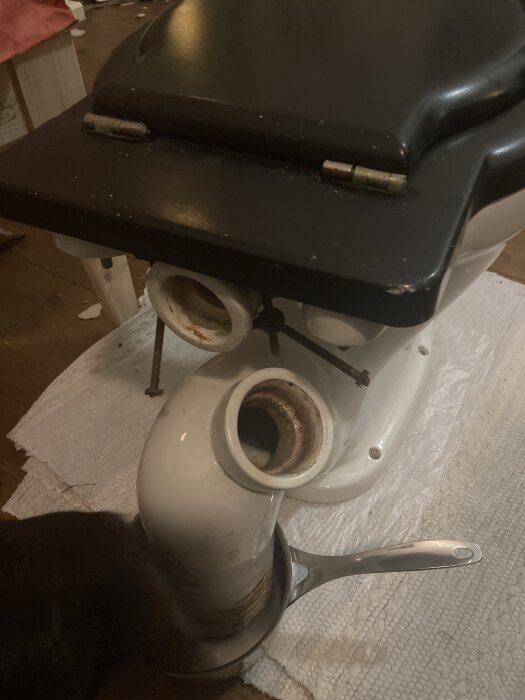 Opluggad toalettanslutning med synlig öppning och handtag av en kastrull.