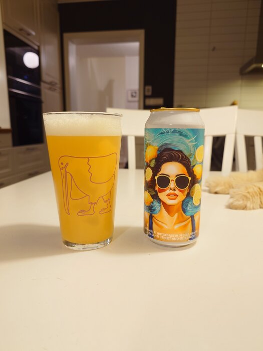 En burk Brygghus 19 öl med färgglad design bredvid ett glas med ljus, skummande öl på ett vitt bord.