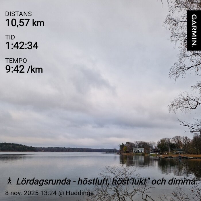 Sjösida med molnig himmel, träd längs stranden och grått vatten i höstlandskap. Garmin-statistik och text om en lördagsrunda syns ovanpå bilden.