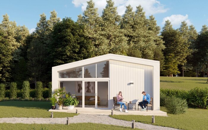 Modernt modulhus i skogsmiljö med två personer sittande på verandan.