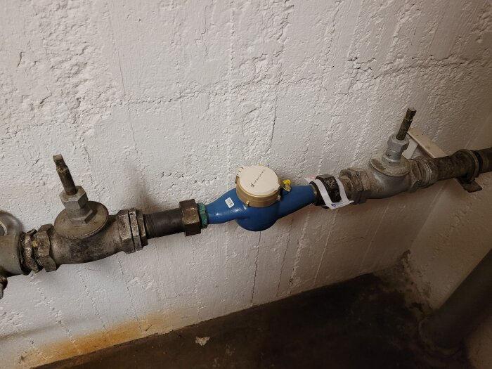 Gammal vattenmätare och ventiler utan avstängningsratt i källare, del av flerbostadshus. Ventilerna behöver troligen bytas ut enligt inlägget.