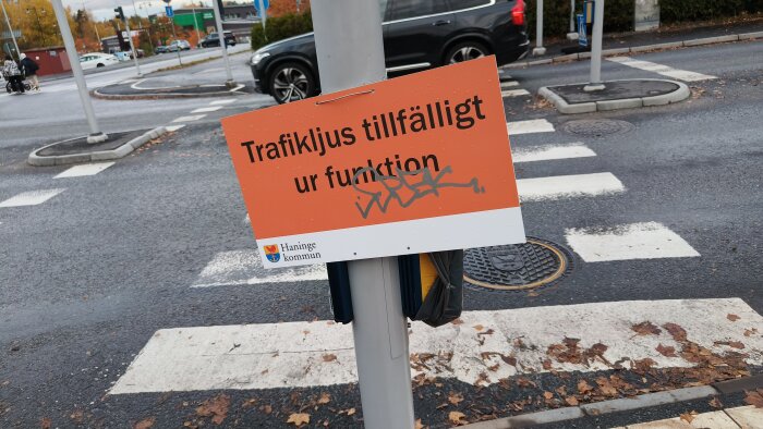 Skylt vid övergångsställe med texten "Trafikljus tillfälligt ur funktion" och Haninge kommuns logotyp.