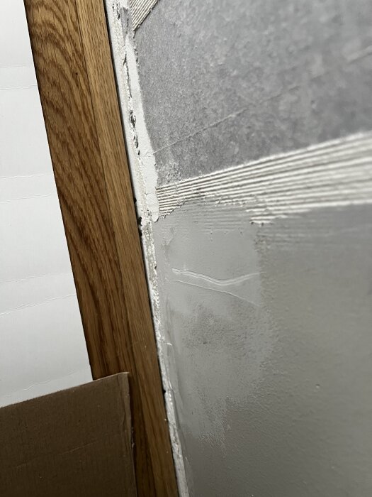 Sovrumsvägg med trälist. Golvet ligger 0-2 mm från väggen. Diskussion om att ta bort golvsocklar och kontrollmäta.