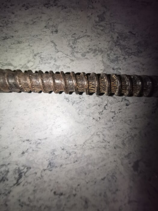 Bild av en gammal, stor skruv med grov gängning som avlägsnats från taket i en lägenhet från 1920-talet.