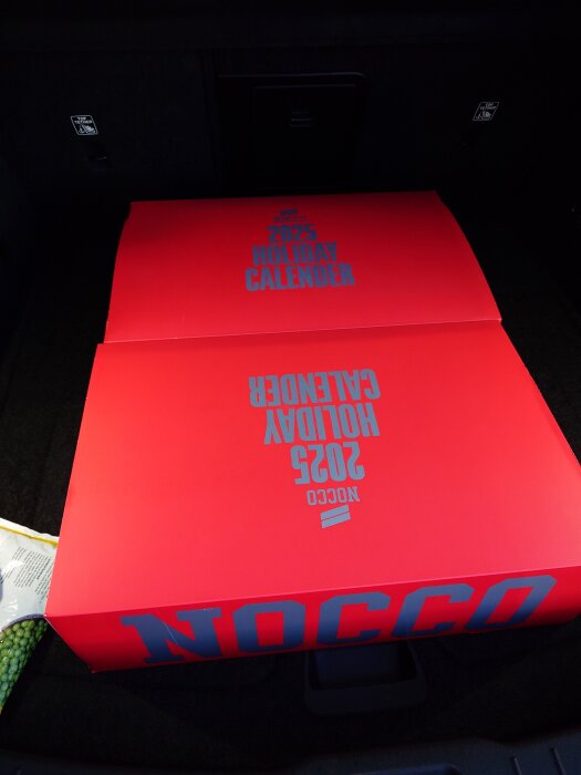 Röd låda i en bil med texten "NOCCO 2025 Holiday Calendar".