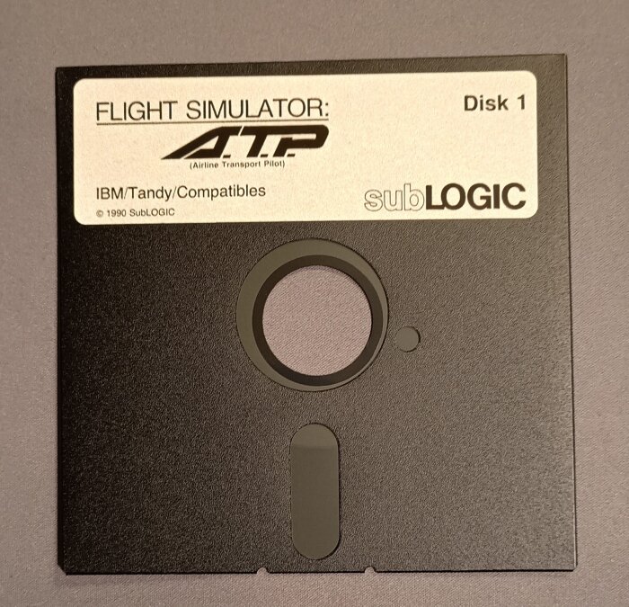 3,5-tums diskett från spelet Flight Simulator: ATP, Disk 1, etikett med IBM/Tandy-kompatibler och SubLOGIC.