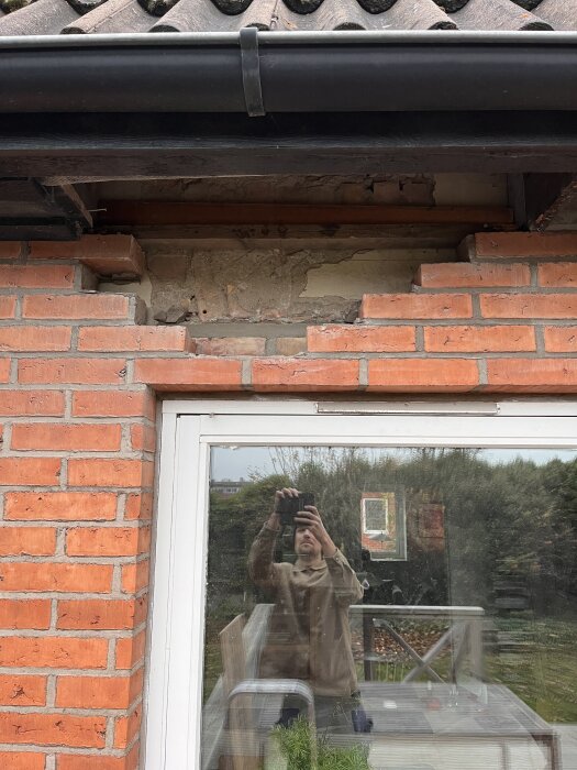 En bild av ett hus med fasadtegel och fönster; en del av fasaden ovanför fönstret har tagits bort för att visa tegelvalvet.