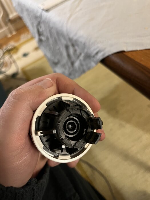 Äldre termostat i handen, del av värmeregulator som lossnat från elementet.