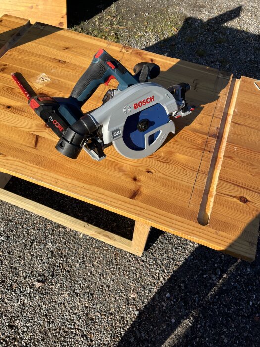 Bosch cirkelsåg utan skena på ett träbord, fotograferad utomhus.